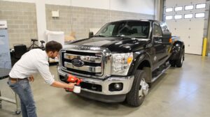 The high gloss, reflective surfaces of chrome-parts are a challenge for measurement technicians. Therefore the chrome radiator grille of the Ford Truck is dulled using an AESUB scanning spray. Since a relatively large area must be sprayed, the spray AESUB green was used. This is applied with a portable spray gun. The spraying process took about one minute.